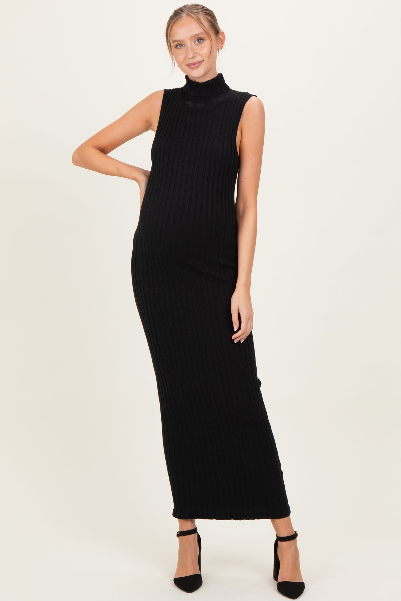 woman wearing a black ribbed maternity maxi dress with a high neck and a visible baby bump