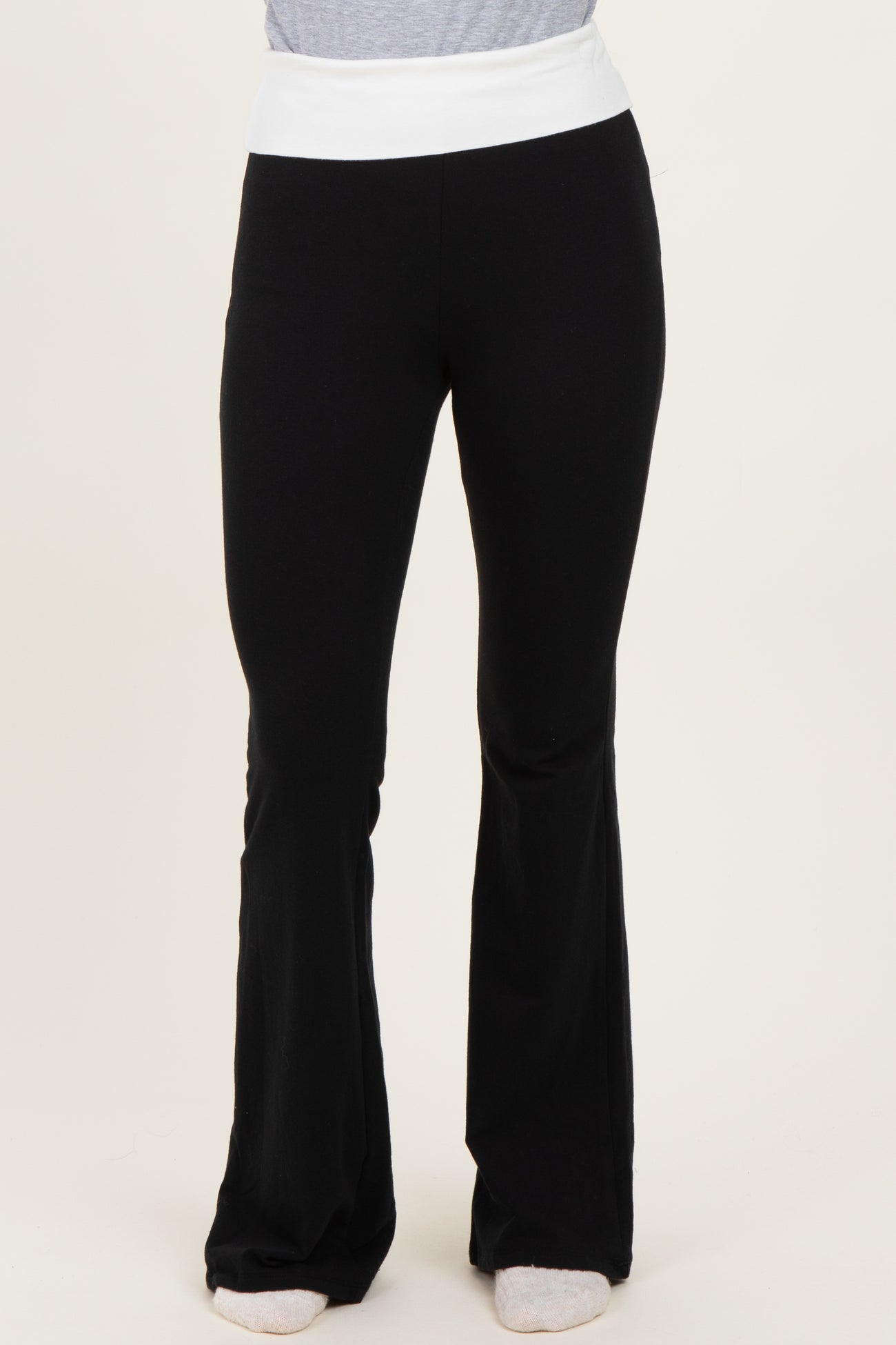 woman wearing black flared yoga pants with a white waistband