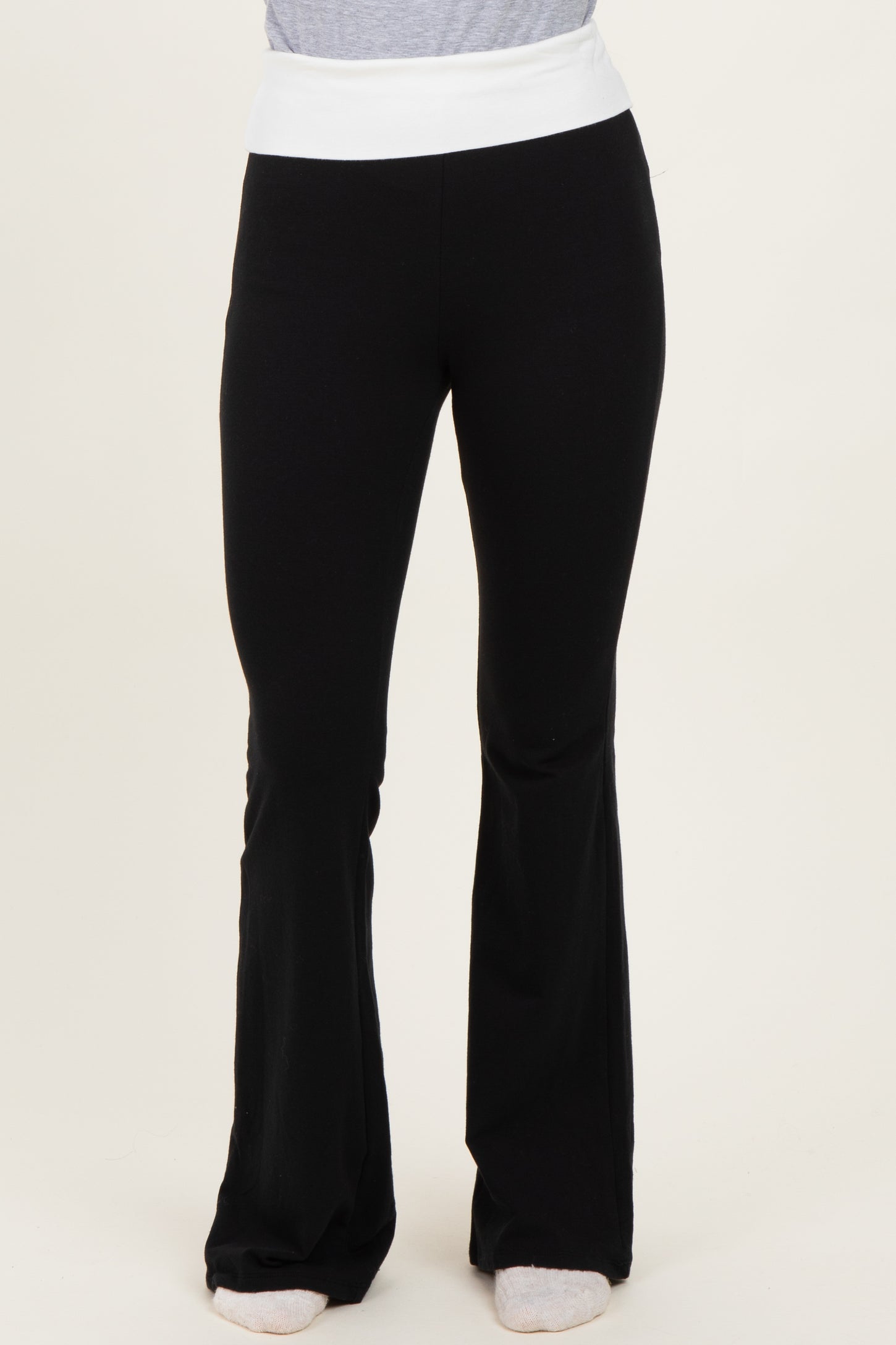 woman wearing black flared yoga pants with a white waistband