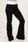 woman wearing black flared pants with a white waistband, styled with a casual top