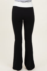 woman wearing black flared yoga pants with a white waistband, seen from the back