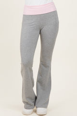 woman wearing gray flared sweatpants with a light pink waistband and white sneakers