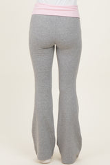 woman wearing gray flared yoga pants with a pink waistband, viewed from the back