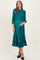 woman wearing a teal maternity dress with smocked bodice and ruffled skirt, holding her baby bump