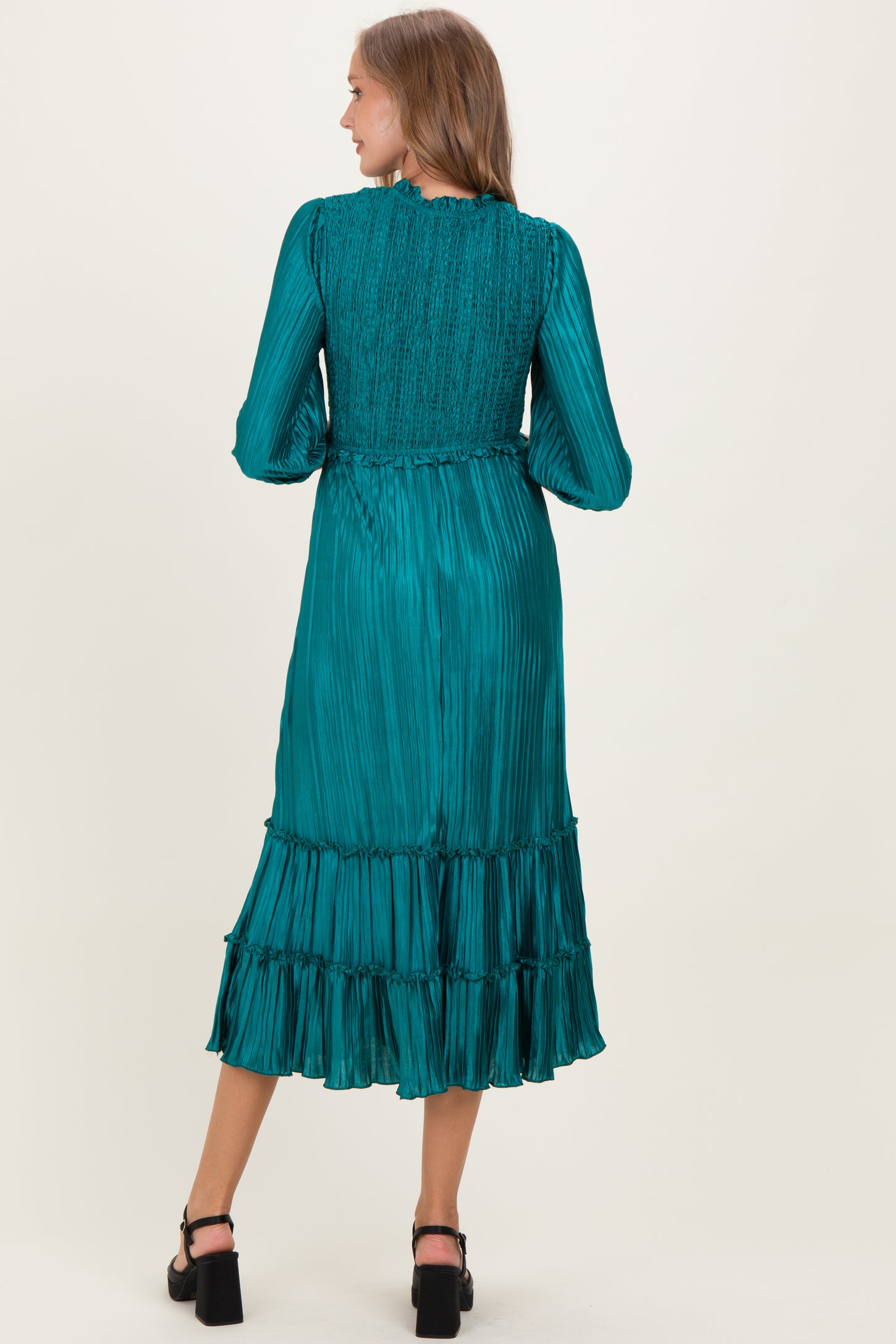 woman wearing a teal maternity dress with a smocked bodice and tiered ruffle hem, seen from the back