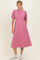 woman wearing a pink midi dress with puff sleeves and pockets, standing in a relaxed pose