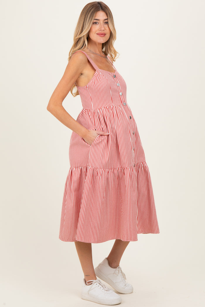 woman wearing a red and white striped maternity dress with buttons and pockets, showcasing her baby bump