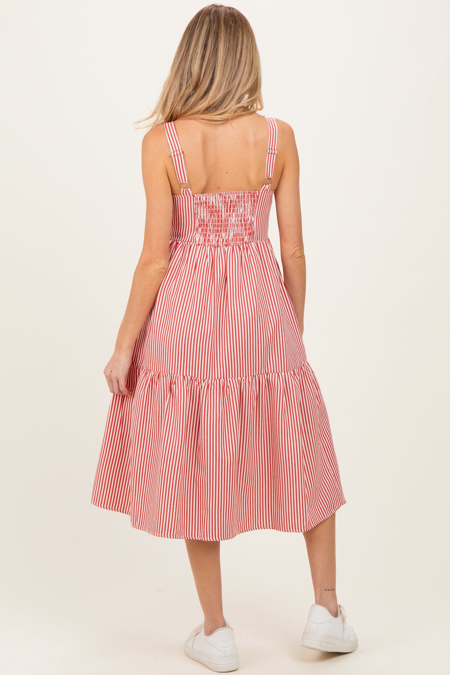 woman wearing a red and white striped maternity dress with a smocked back and a tiered skirt