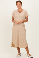 woman wearing a beige short sleeve midi dress with button details and side slits, standing against a neutral background