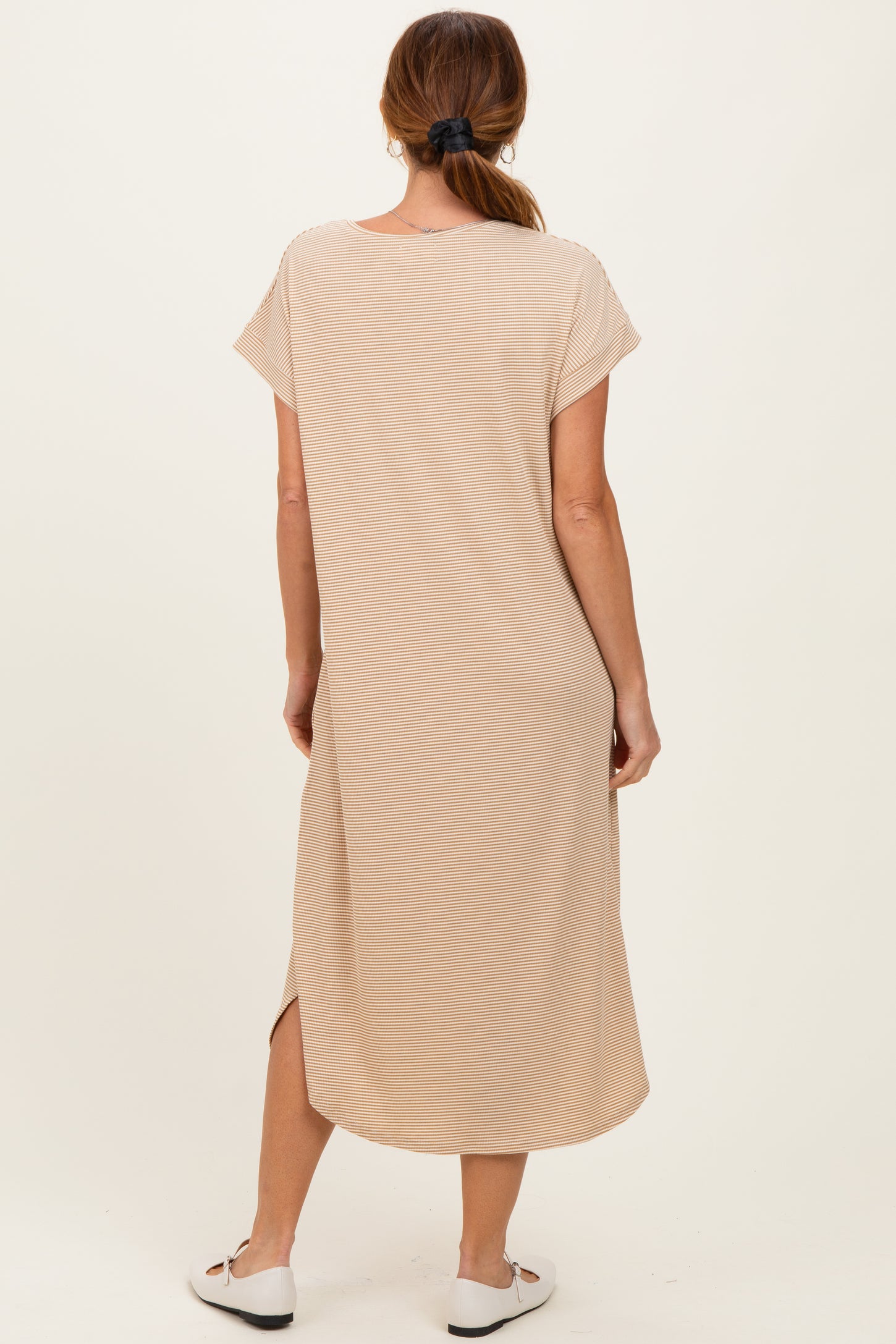 woman wearing a beige short sleeve maxi dress with side slits, shown from the back