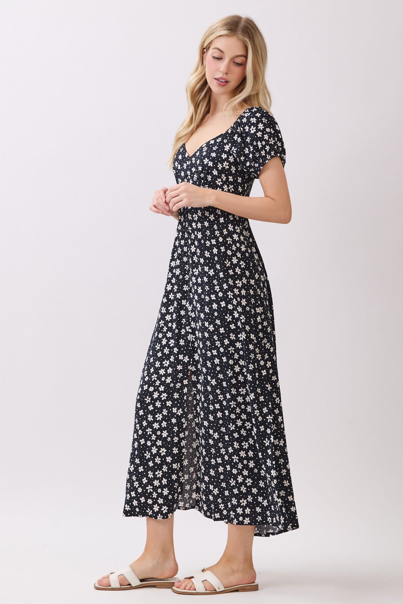 woman wearing a navy blue floral maxi dress with short puff sleeves and a fitted bodice