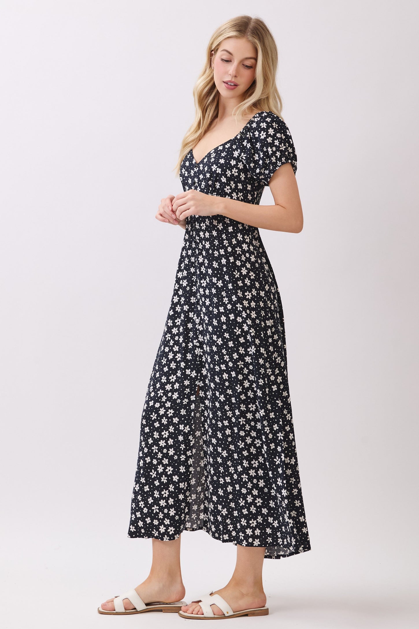 woman wearing a navy blue floral maxi dress with short puff sleeves and a fitted bodice