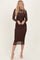 woman wearing a brown long sleeve midi dress with polka dot detailing and a fitted silhouette, styled with nude heels