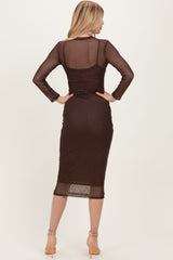 woman wearing a brown sheer long sleeve dress with polka dots and a fitted silhouette, shown from the back