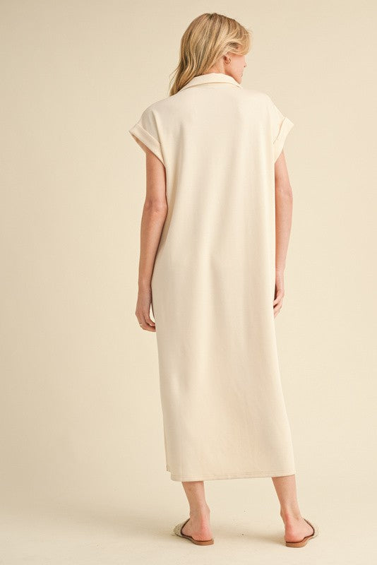 woman wearing a light beige sleeveless maxi dress with a collar, viewed from the back