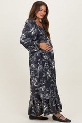 woman wearing a black floral maternity maxi dress and holding her baby bump