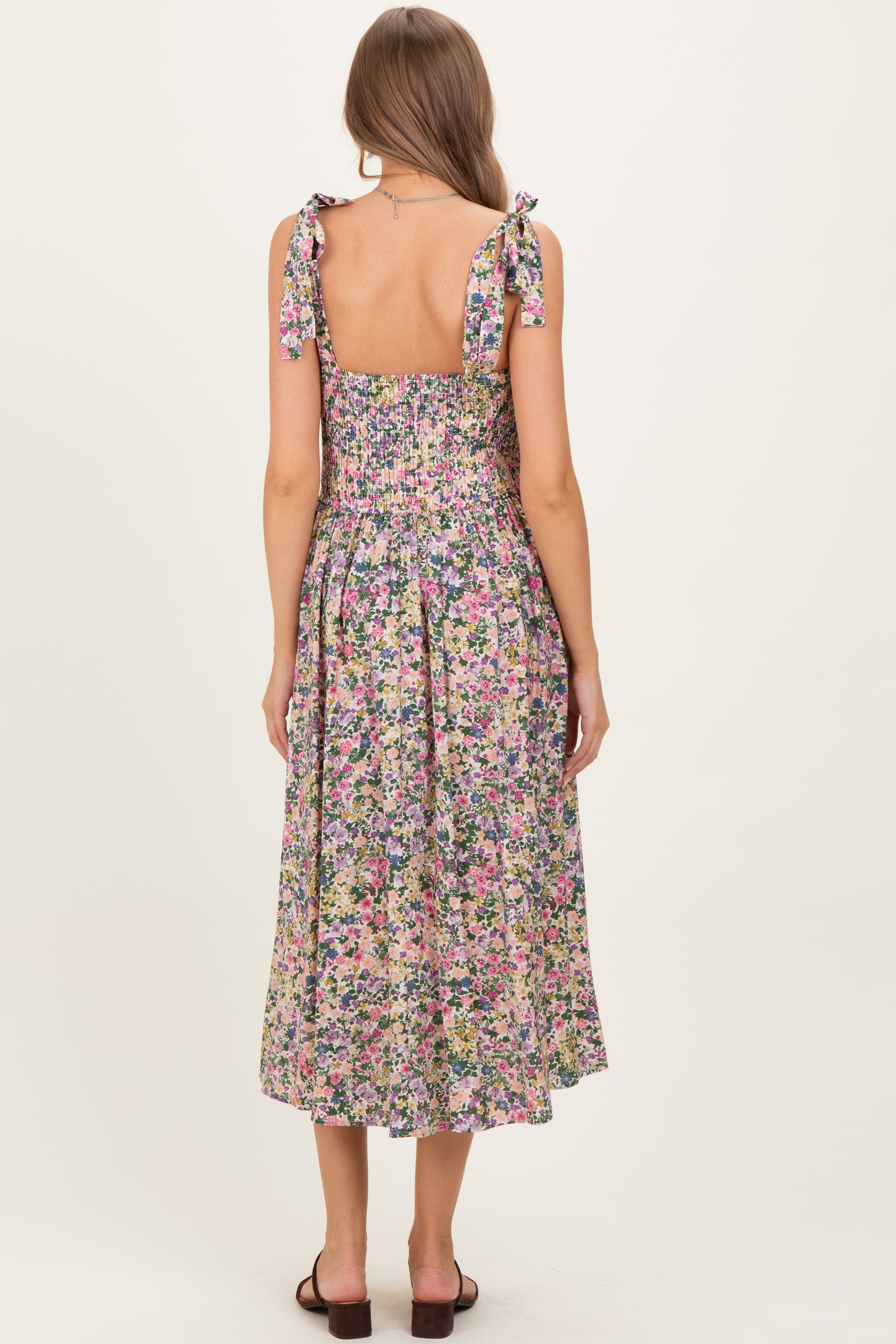 woman wearing a floral print midi maternity dress with tie straps and smocked back detail
