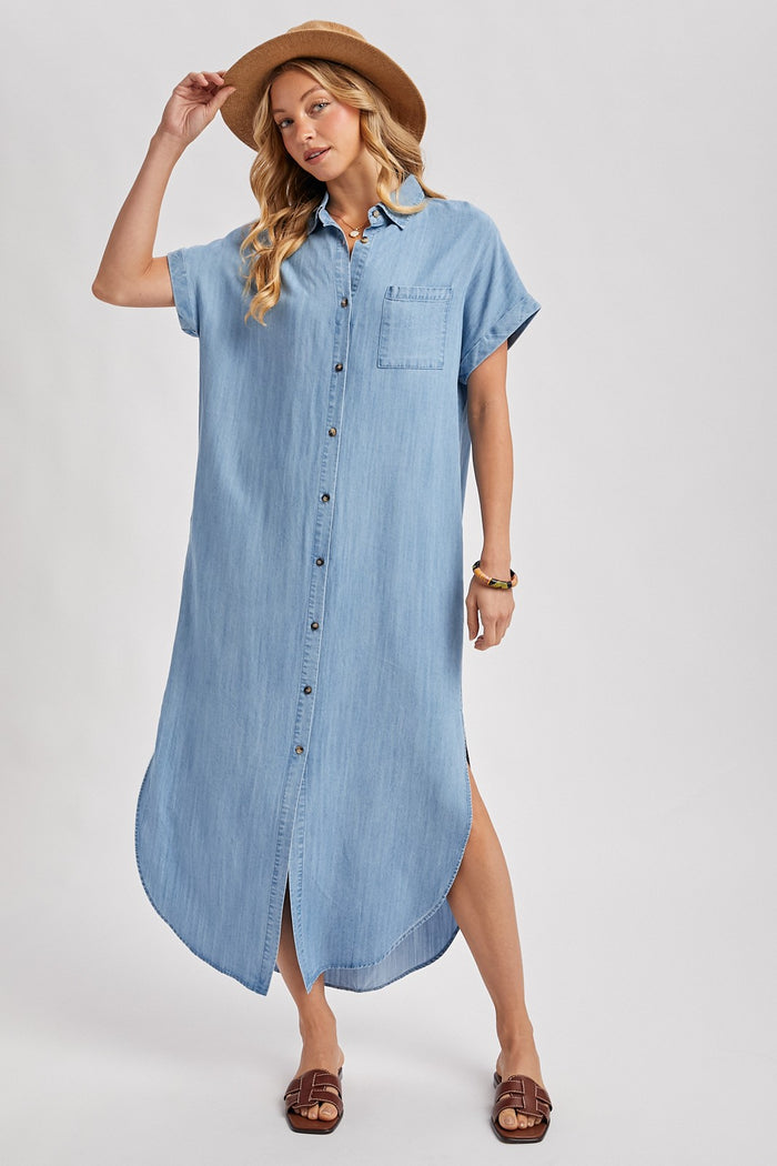 woman wearing a denim button-up shirt dress with short sleeves and a pocket, paired with a wide-brimmed hat
