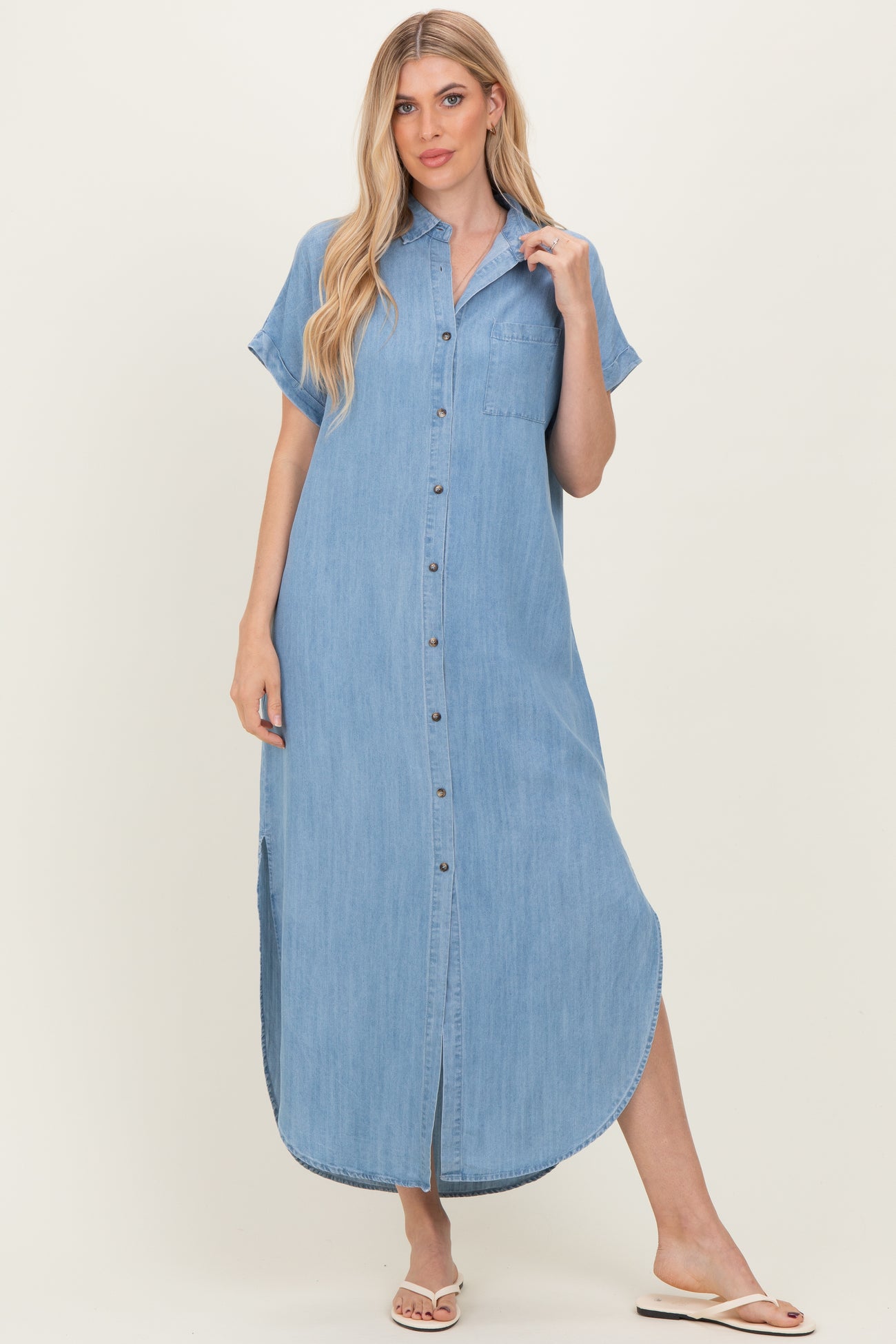 woman wearing a light blue denim shirt dress with short sleeves and buttons down the front