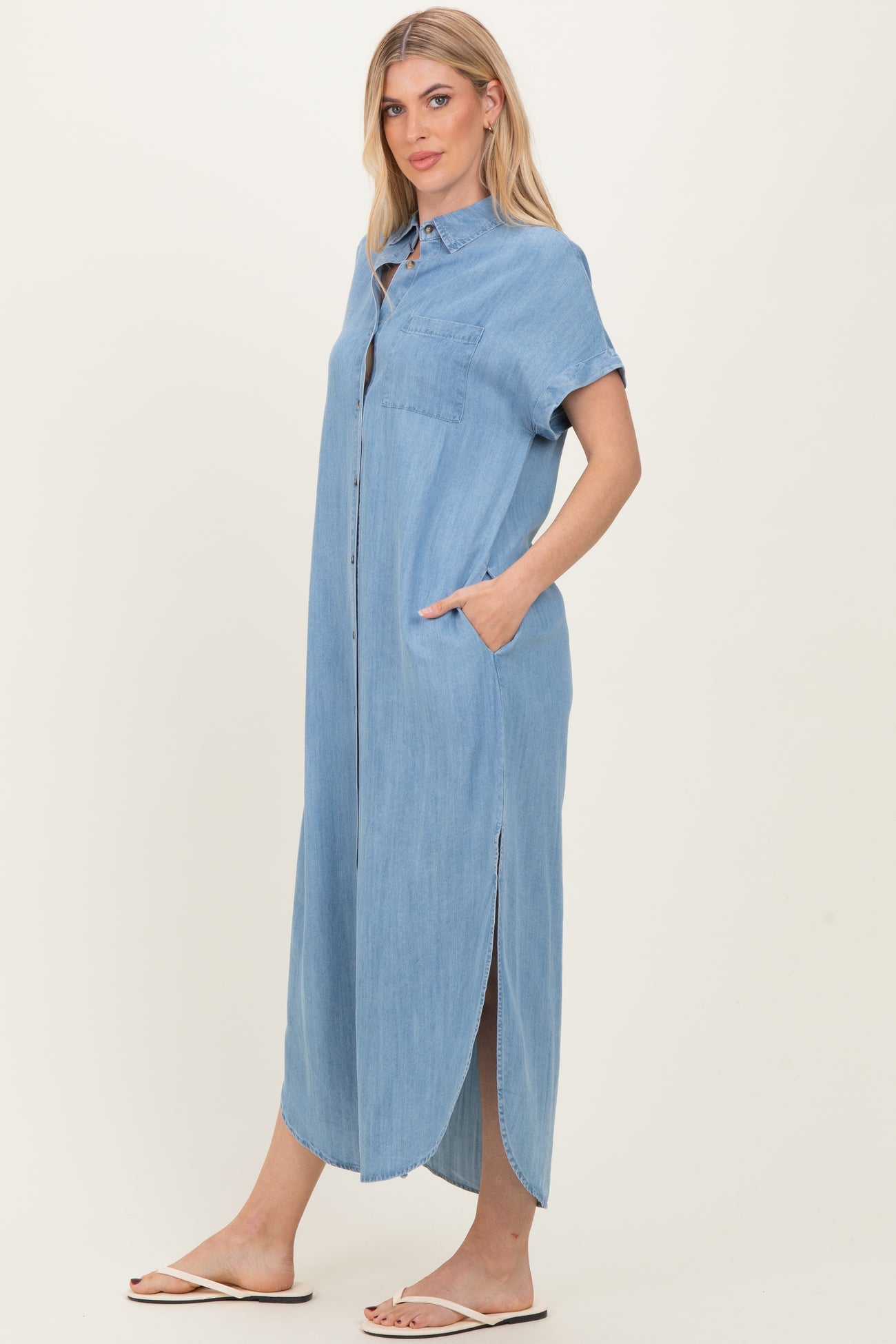 woman wearing a light blue denim maxi shirt dress with short sleeves and side pockets