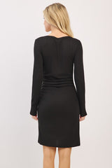 woman wearing a black long sleeve bodycon dress seen from the back with ruched detailing