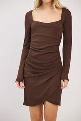 woman wearing a brown long sleeve bodycon dress with a square neckline and ruching detail on the front