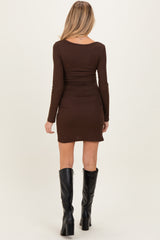 woman wearing a brown long sleeve maternity dress with side ruching, seen from the back