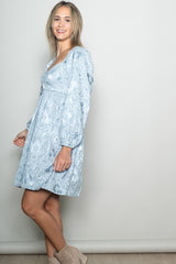 woman wearing a light blue floral print long sleeve dress with a gathered waist and balloon sleeves