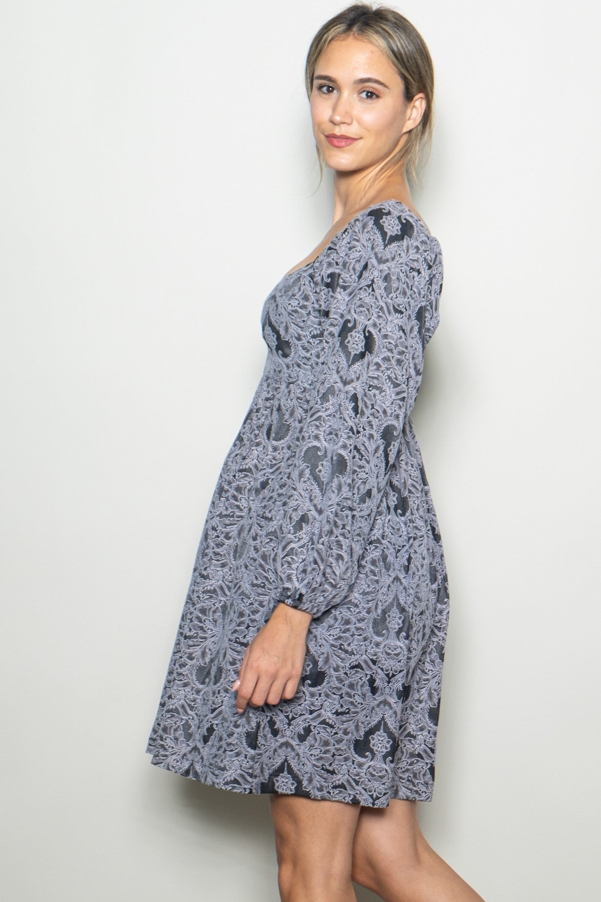 woman wearing a grey floral pattern long sleeve dress with a relaxed fit