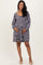 woman wearing a gray patterned maternity dress with long sleeves and a relaxed fit, showcasing her baby bump