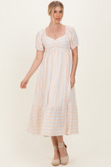 woman wearing a white striped maxi dress with puff sleeves and a tiered hemline
