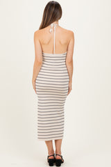 woman wearing a back view of a striped maternity dress with a halter neck and a fitted silhouette