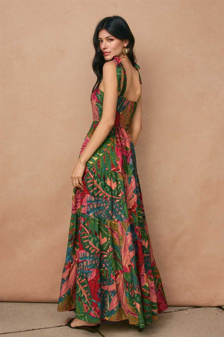 woman wearing a colorful floral print maxi dress with a back cutout and tie straps