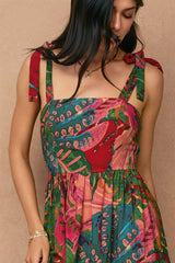 woman wearing a colorful floral print dress with tie straps and a fitted bodice