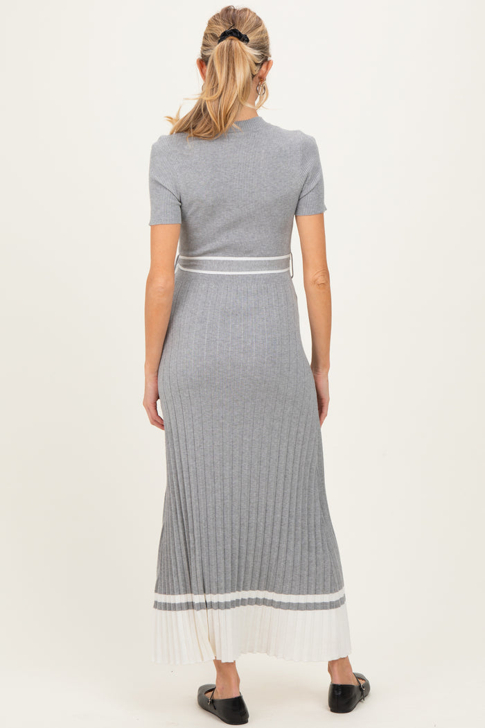 woman wearing a grey ribbed maternity dress with short sleeves and pleated hem, showing her baby bump from the back