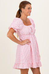 woman wearing a light pink puff sleeve dress with a ruffled hem and square neckline