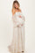woman wearing a strapless floral maternity gown with puff sleeves, holding her baby bump