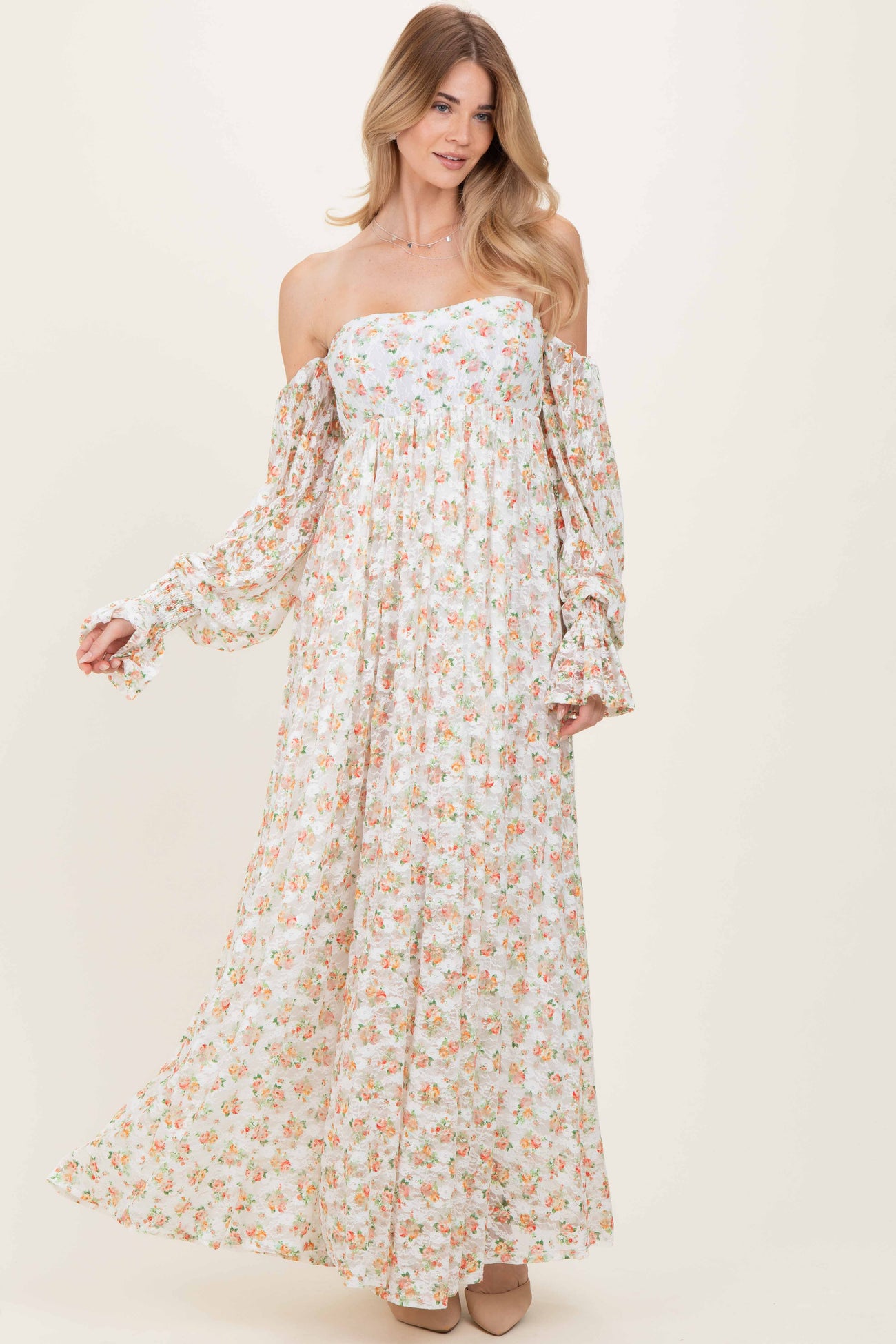 woman wearing a floral off-the-shoulder maxi dress with long puff sleeves and a flowing skirt
