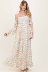 woman wearing a floral off-the-shoulder maxi dress with long puff sleeves and a flowing skirt