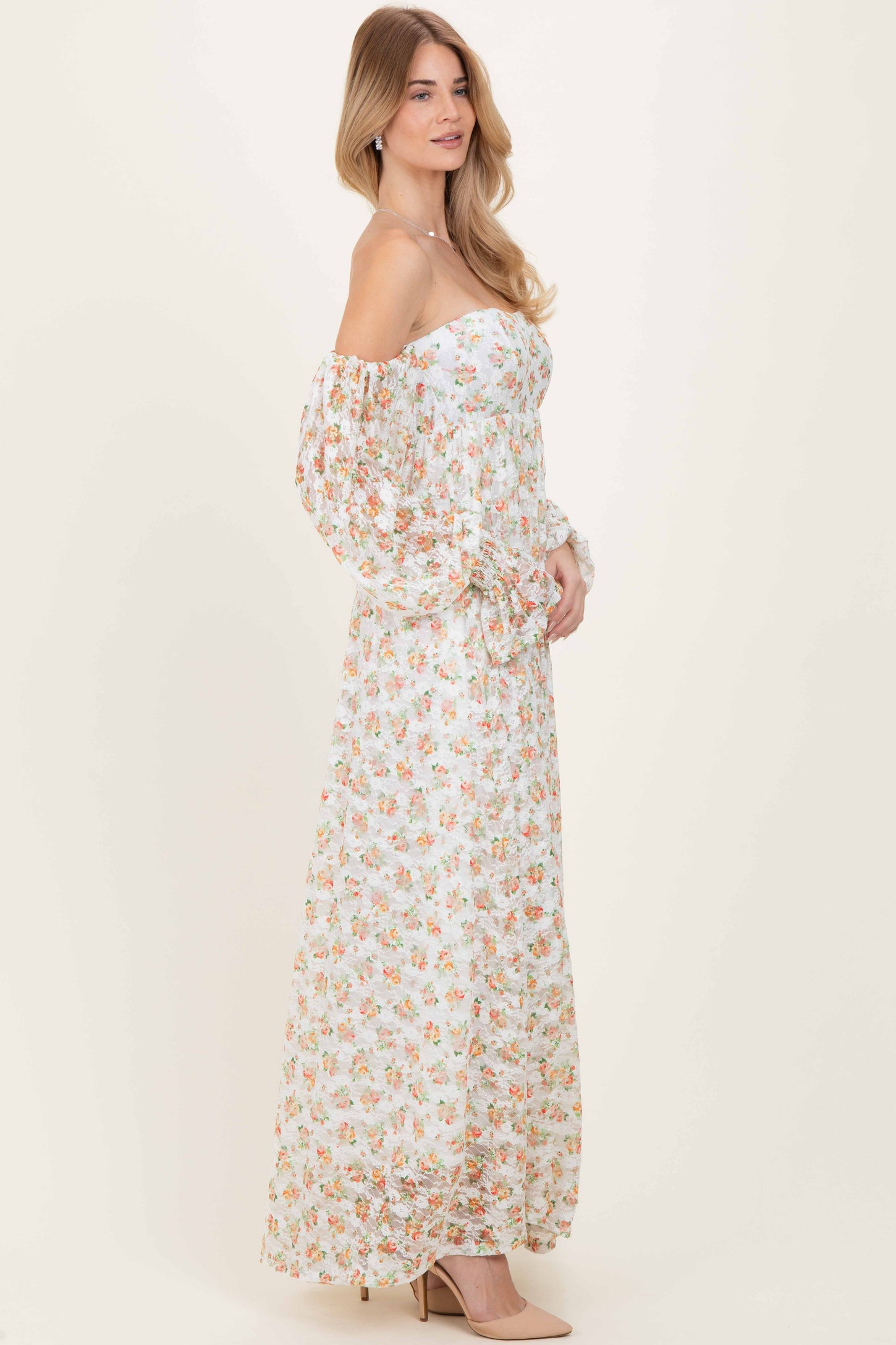 woman wearing a floral off-the-shoulder maxi dress with puff sleeves and a fitted bodice