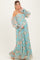 woman wearing a blue floral off-the-shoulder maternity dress, showcasing her baby bump