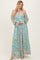 woman wearing a light blue off-the-shoulder floral maxi dress with full sleeves and a smocked bodice