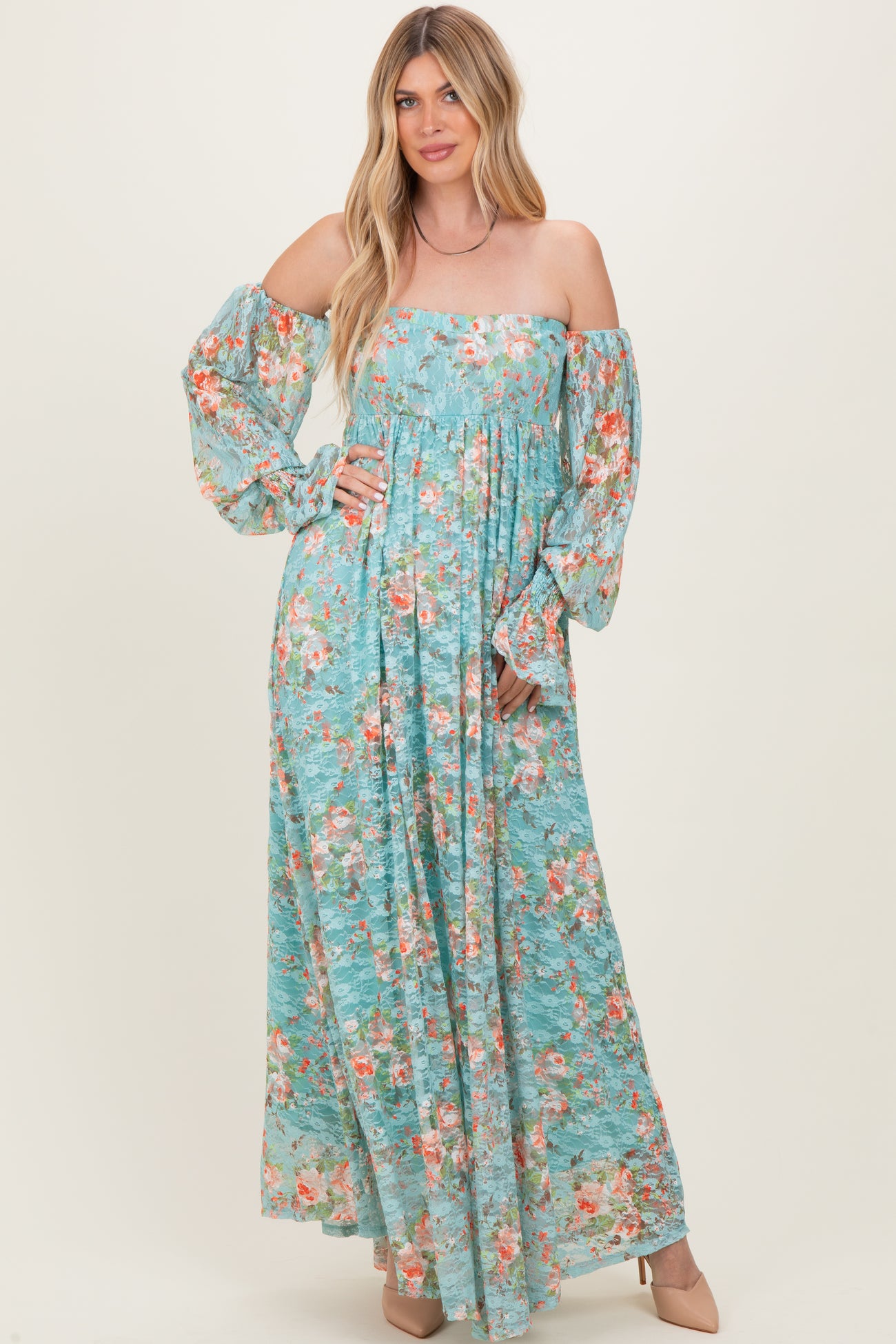 woman wearing a blue floral maxi dress with off-the-shoulder sleeves and a fitted bodice