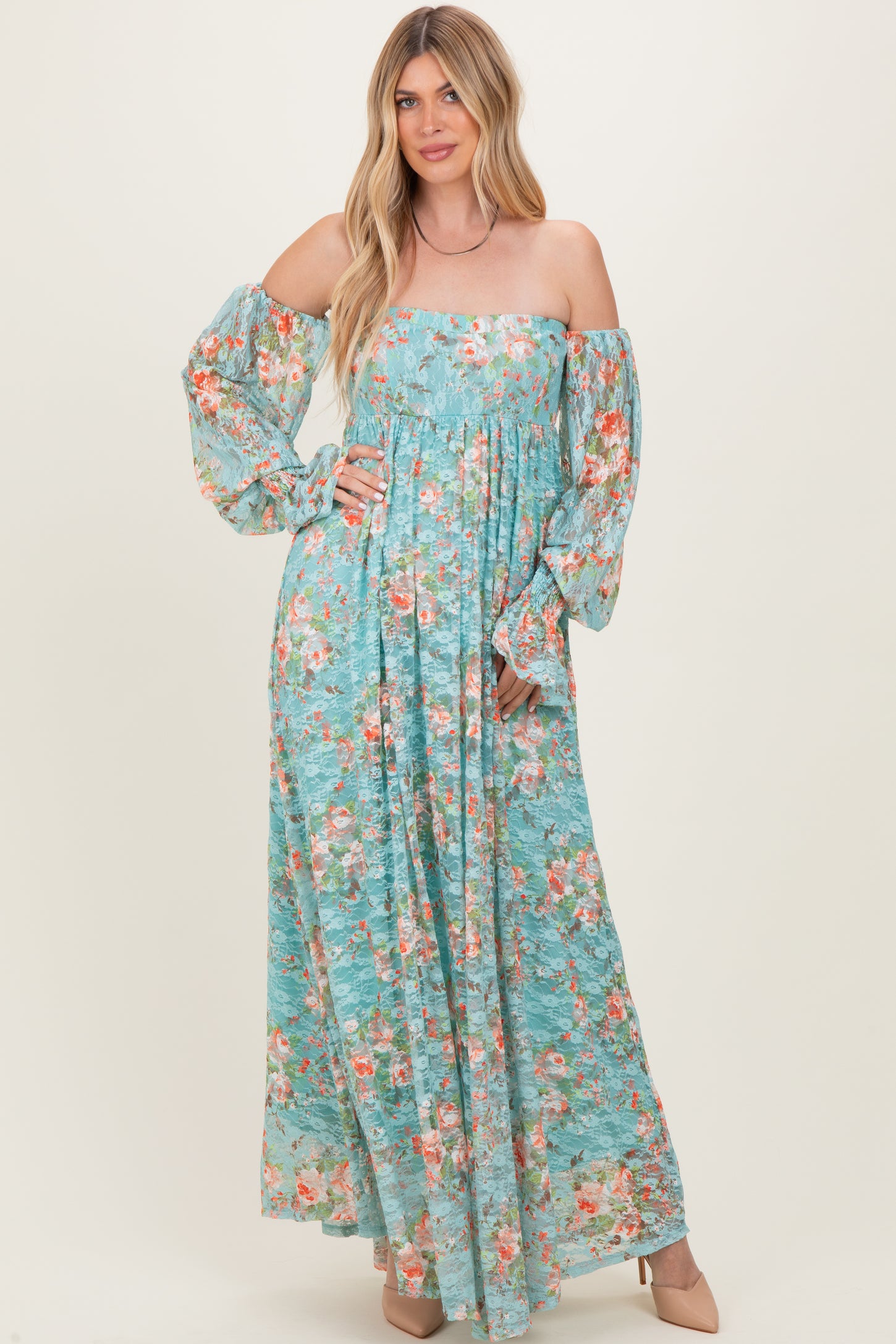 woman wearing a blue floral maxi dress with off-the-shoulder sleeves and a fitted bodice