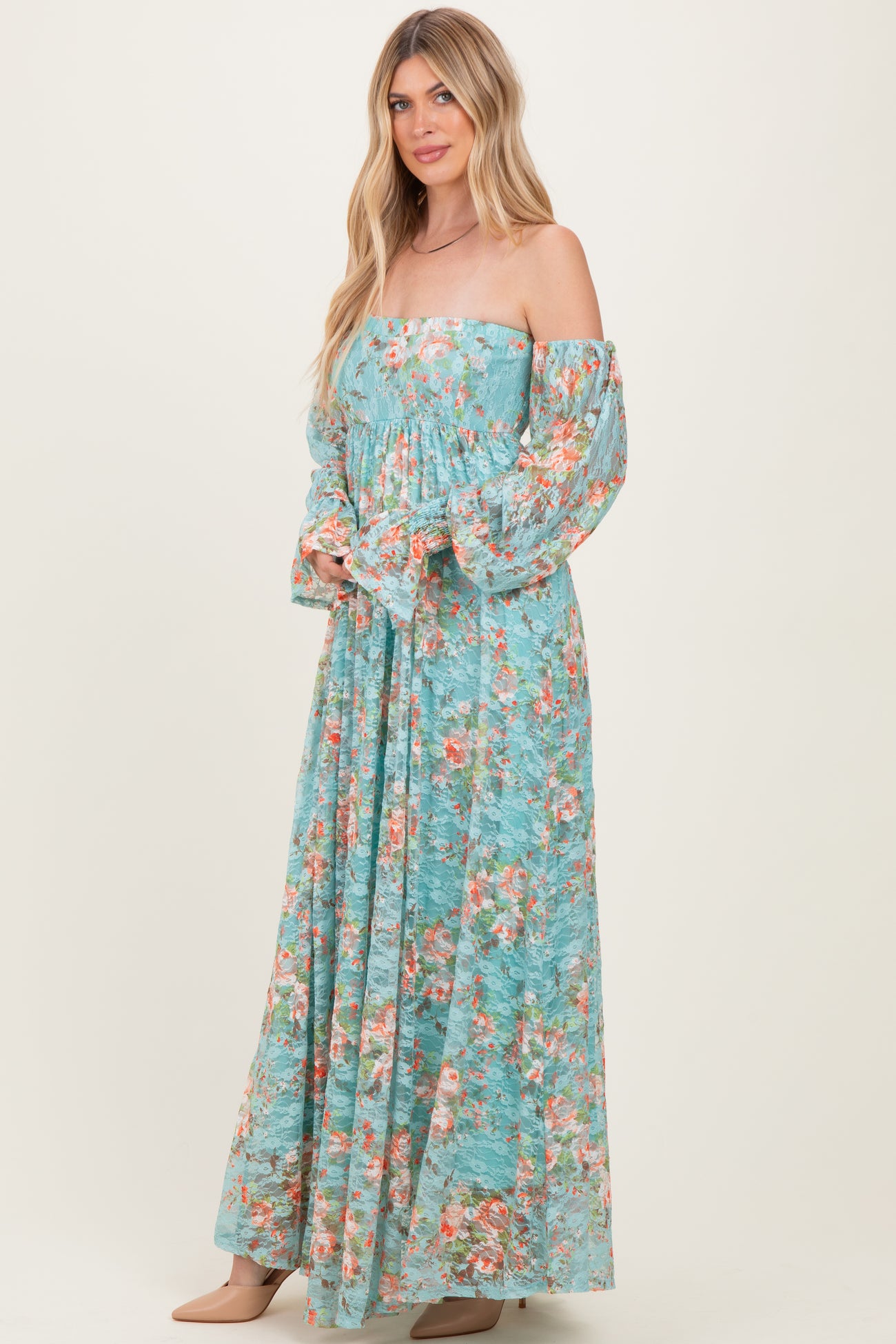 woman wearing a floral off-the-shoulder maxi dress in light blue with long sleeves and flowing design