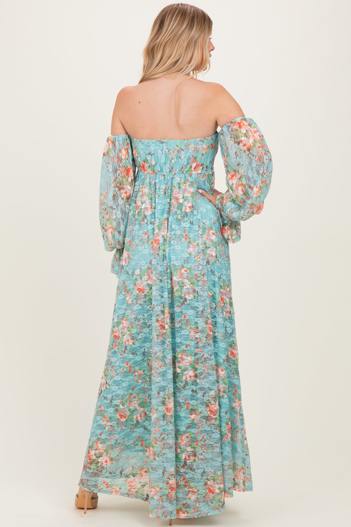 woman wearing a flowy off-the-shoulder maxi dress in light blue with floral print and puff sleeves
