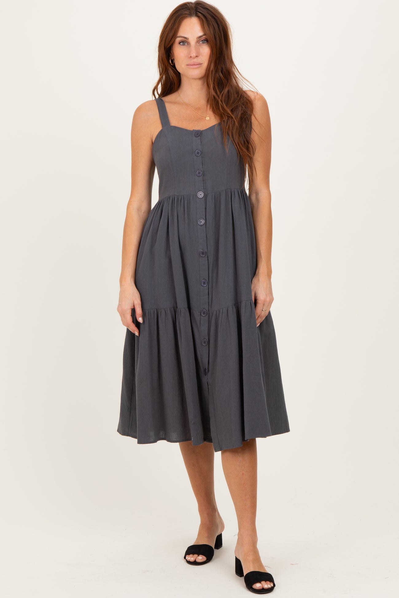 woman wearing a dark grey button-up sleeveless midi dress with a tiered skirt and adjustable straps