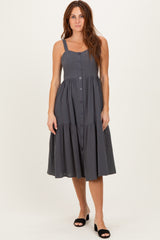 woman wearing a dark grey button-up sleeveless midi dress with a tiered skirt and adjustable straps
