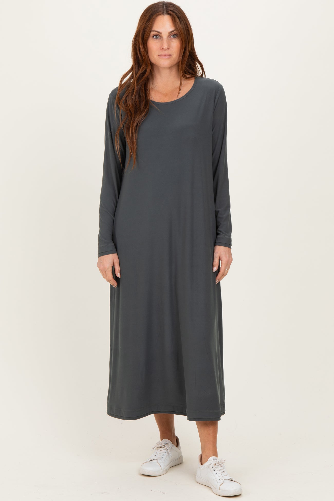 woman wearing a long grey maxi dress with long sleeves and a relaxed fit