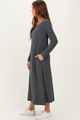 woman wearing a charcoal grey long sleeve maxi dress with pockets and white sneakers